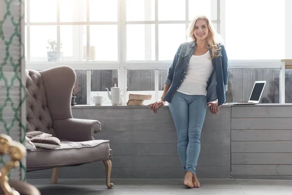 Pretty blond lady standing at big panoramic window