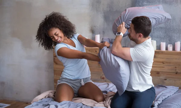 Couple having a morning pillow fight