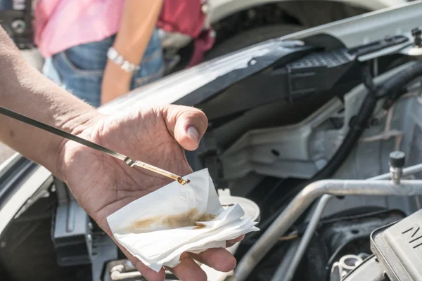 Mechanic checking motor oil