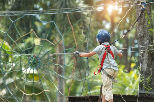 Kid climbing in adventure rope park