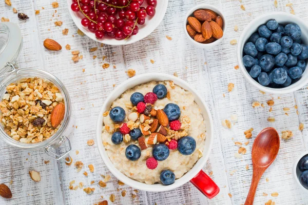 Healthy breakfast with oatmeal porridge, fresh berries and muesli