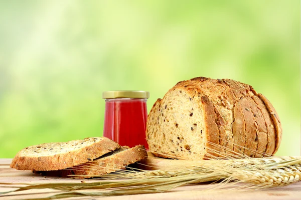 Bread and jam on wooden and blur green background.