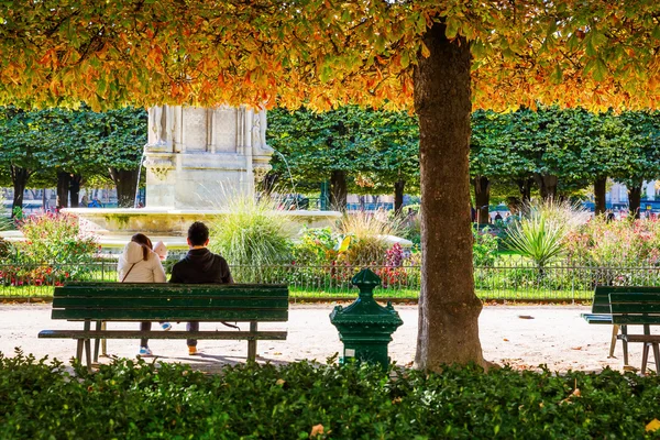 Couple sitting in the park of Notre Dame of Paris