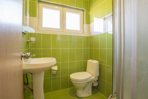 Interior of a bathroom with green tiles