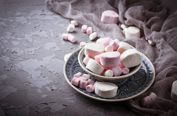 White and pink marshmallows on gray concrete background