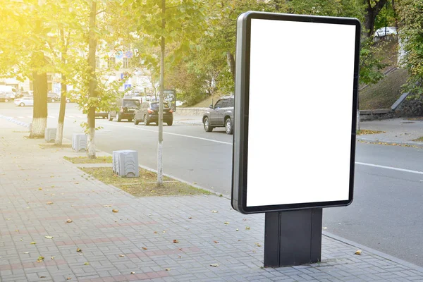 Blank billboard with copy space for your text message or content, outdoors advertising mock up, public information board on city road, flare sun light. Empty Lightbox on urban setting sideline