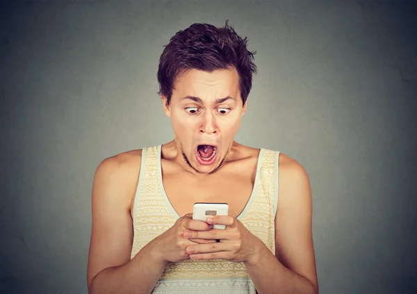 Anxious shocked man looking at phone seeing bad news photos