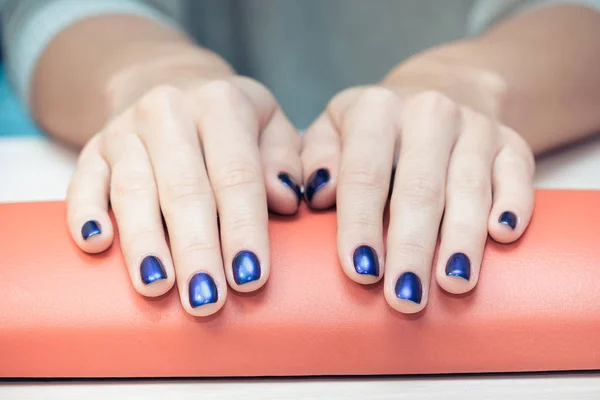 Female hands with  blue nail Polish, close-up