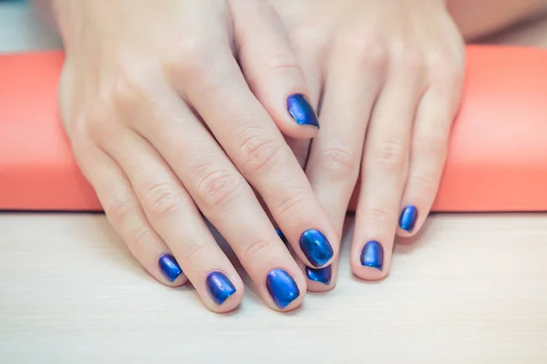 Female hands with  blue nail Polish, close-up