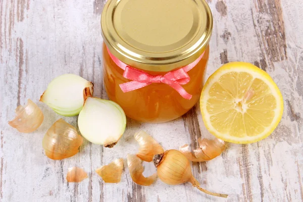 Fresh organic honey in glass jar, onions and lemon, healthy nutrition and strengthening immunity