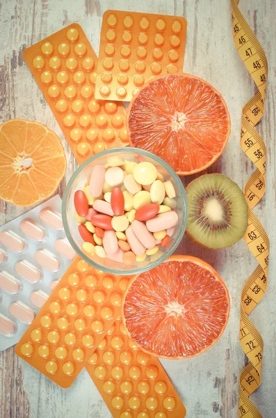 Vintage photo, Natural fruits, centimeter and pills, slimming, choice between healthy nutrition and medical supplements