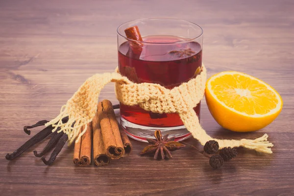 Glass of mulled wine wrapped scarf with fresh fragrant spices