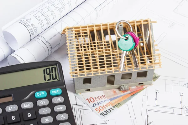 House under construction, keys, calculator, currencies euro and electrical drawings, concept of building home