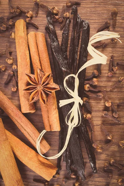 Vintage photo, Vanilla, cinnamon sticks, star anise and cloves on wooden surface