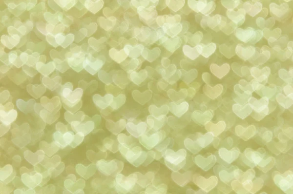 Defocused abstract gold hearts light background