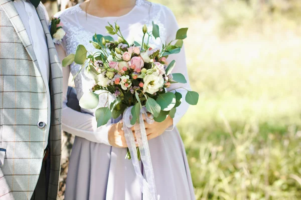 Original bouquet of flowers in the hands of the girl