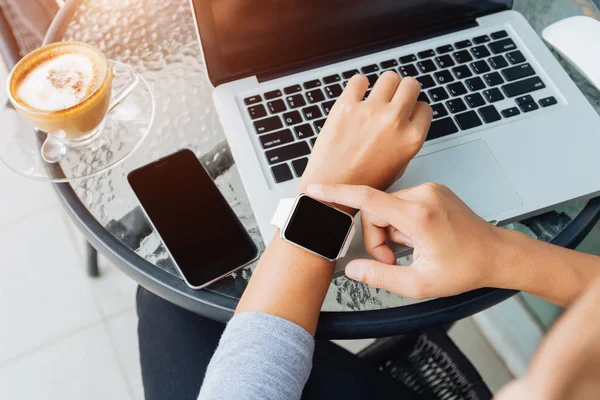 Woman using smart watch in coffee shop, modern city lifestyle