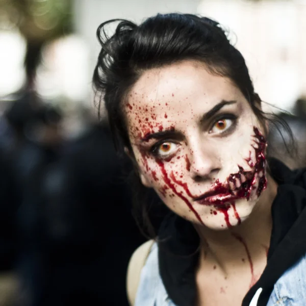 woman dressed as a zombie parades on a street during a zombie walk in Paris.