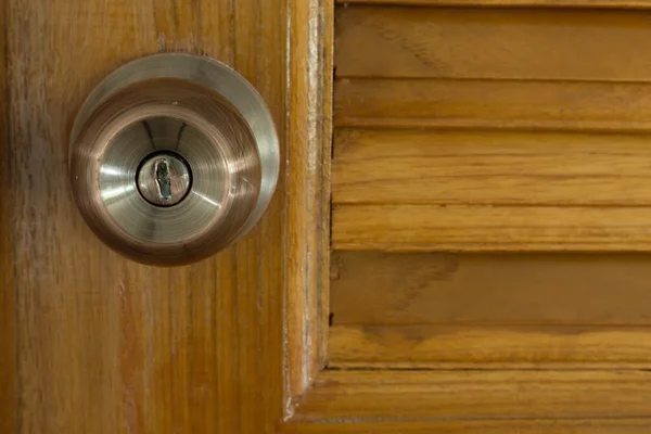 Door knob and keyhole on wooden door