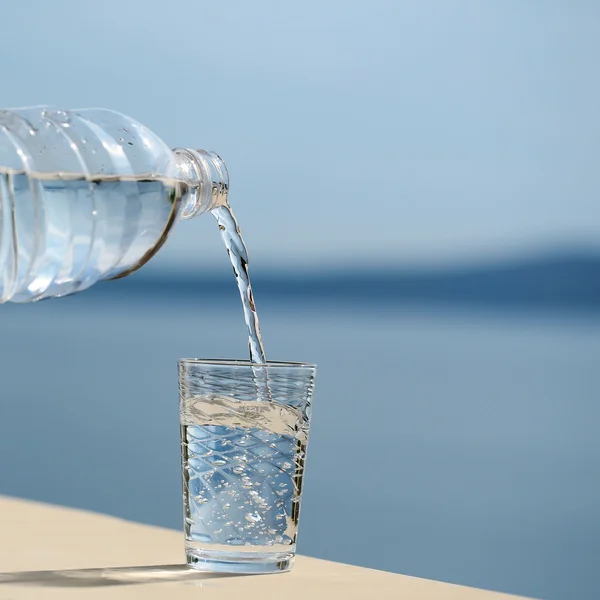 Water pouring into glass from bottle