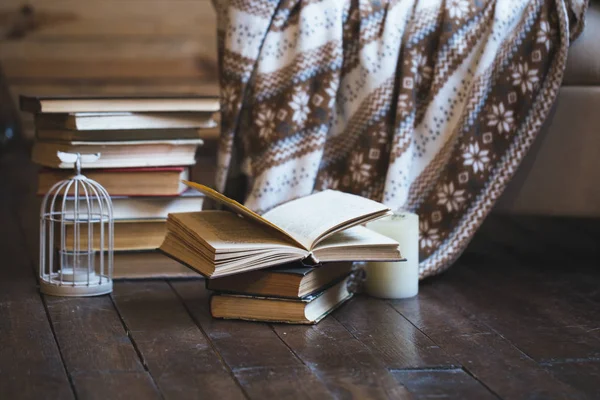 Stack of books with warm plaid on chair
