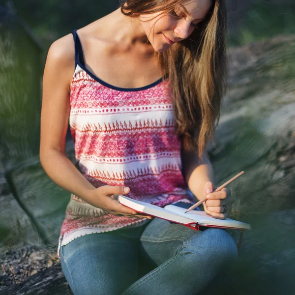 Woman writing notes in nature