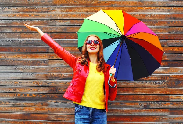 Fashion happy woman with colorful umbrella in autumn day over wo