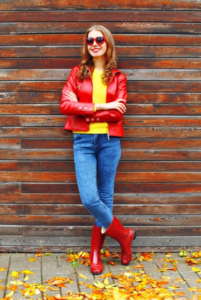 Fashion pretty woman wearing a red leather jacket and rubber boo