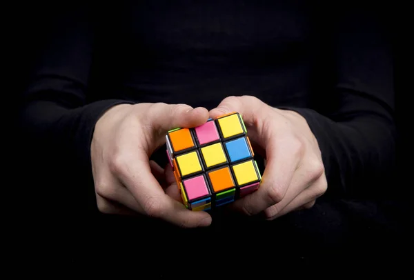 Close-up of a human hand with colorful cube