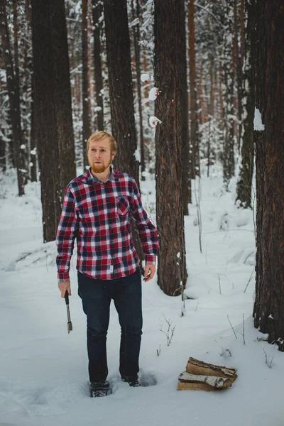 Bearded man with an hatchet in the winter forest
