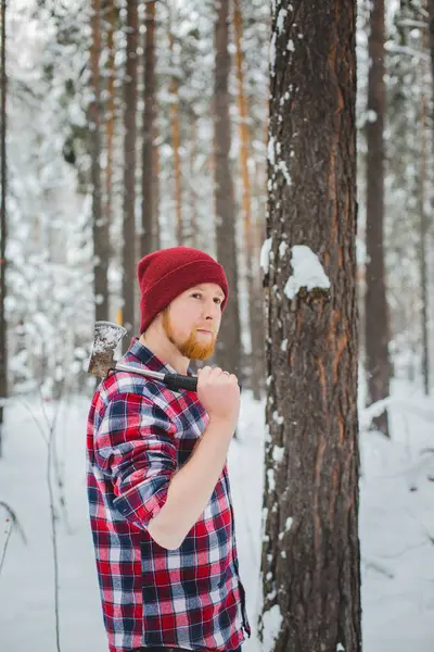 Bearded man with an hatchet in the winter forest