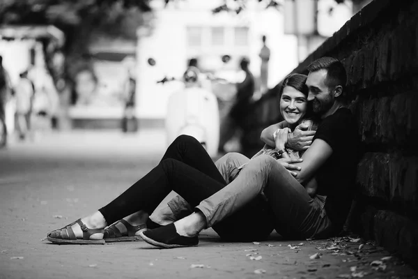 Young beautiful couple sitting on the ground