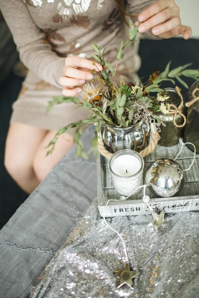 Florist female works with flowers decoration on wooden table