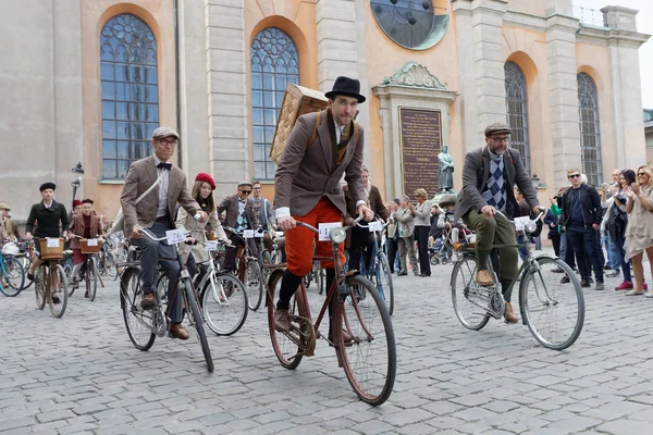 Group of elegant cycling people wearing old fashioned tweed clot