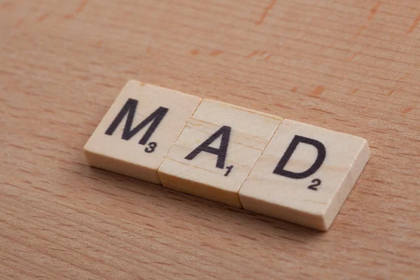 Scrabble letters spelling the word mad.
