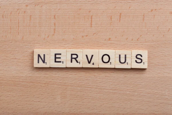 Scrabble letters spelling the word nervous.
