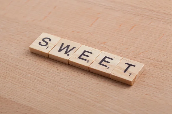 Scrabble letters spelling the word sweet.