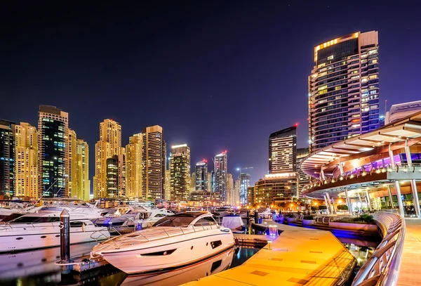 Incredible colorful night dubai marina skyline. Luxury yacht dock. Dubai, United Arab Emirates.