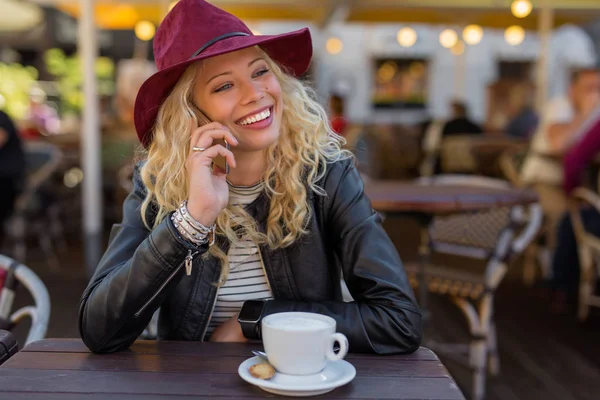 Woman having coffee and talking on the phone