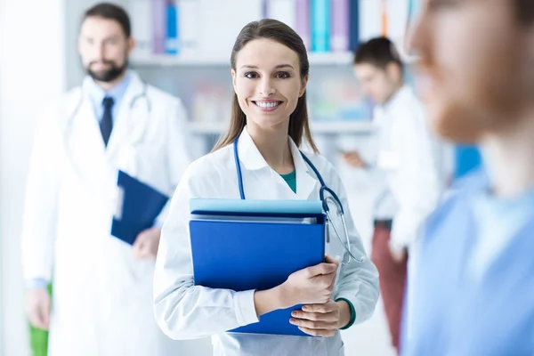 Confident female doctor holding medical records