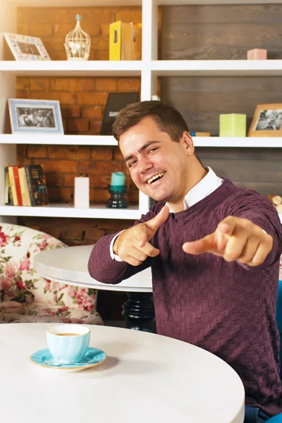 Young man smiling and pointing at you with both hands