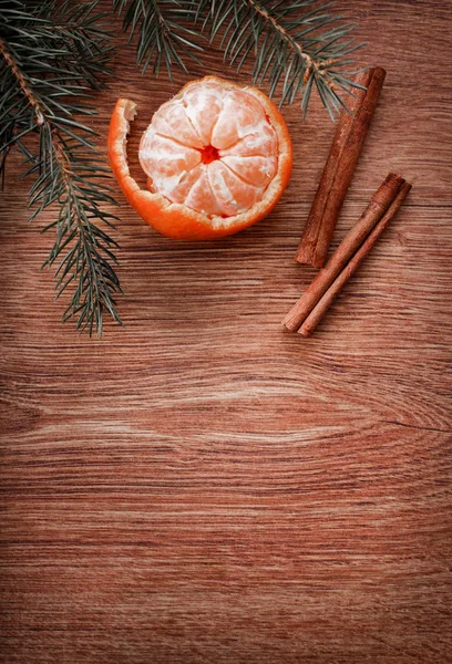 Christmas ornaments, food decor and fir tree branch on a rustic wooden background. Xmas card. Happy New Year. Top view with copy space