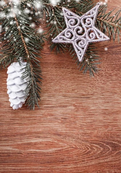 Silver Christmas ornaments and fir tree branch on a rustic wooden background. Xmas card. Happy New Year. Top view with copy space