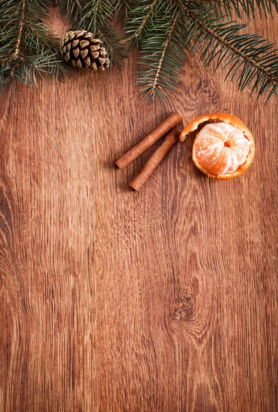 Christmas ornaments, food decor and fir tree branch on a rustic wooden background. Xmas card. Happy New Year. Top view with copy space