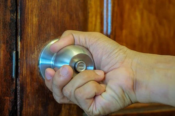 Hand on door knob.