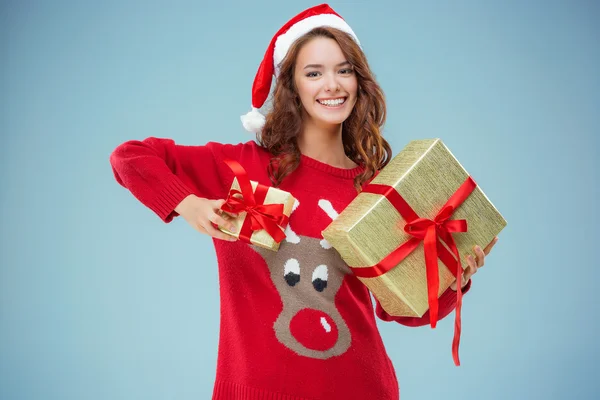 Girl dressed in santa hat with a Christmas gifts