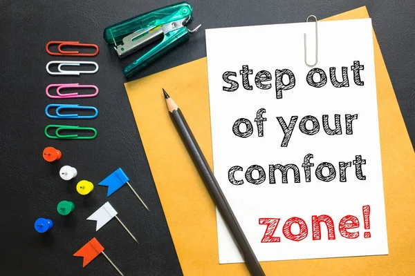 Text step out of your comfort zone on white paper / business concept