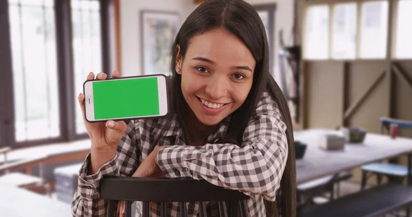 Mexican woman student holding smartphone with green screen