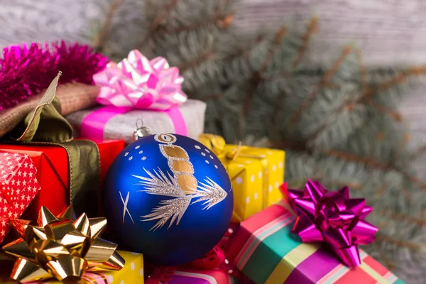 Beautiful blue ball with a candle on a pile of gifts.