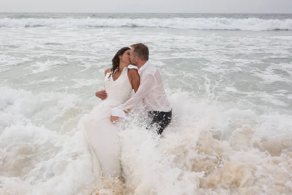 Kissing loving wedding couple in the water have fun